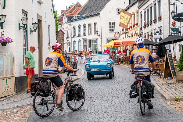 Cyclists in the centre of Thorn with an oldsmobile approaching