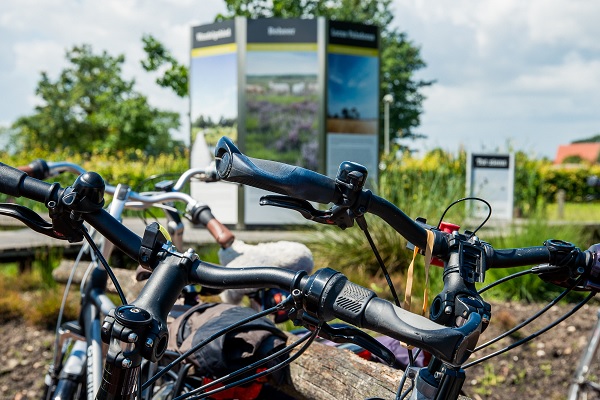Fietsen staan klaar bij het bord van Buitencentrum De Pelen
