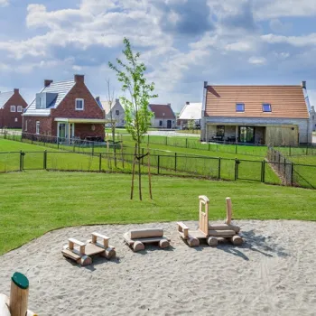 Vakantiepark met moderne huisjes, ruime tuinen en een speeltuin voor kinderen.
